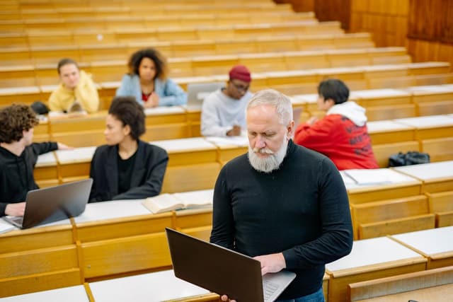 An adult learner using a laptop in a lecture hall