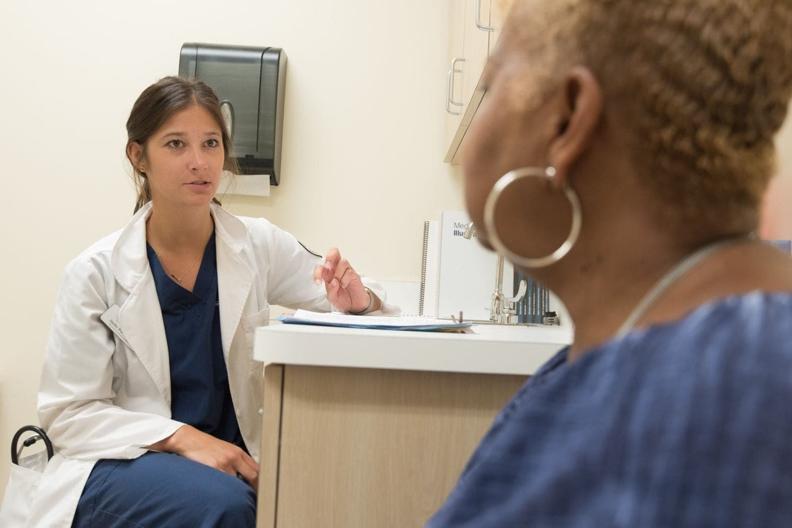 A doctor gesturing while explaining something to a patient