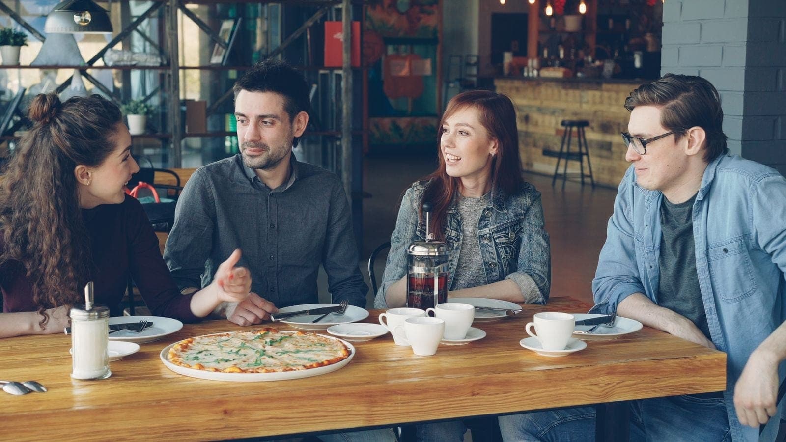 Group of Friends Enjoying Pizza in Cafe