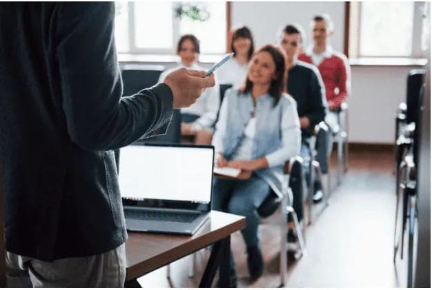 An instructor addressing attentive students in a classroom